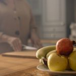 A close-up of fresh fruits on a plate in a cozy kitchen, perfect for healthy diet concepts.